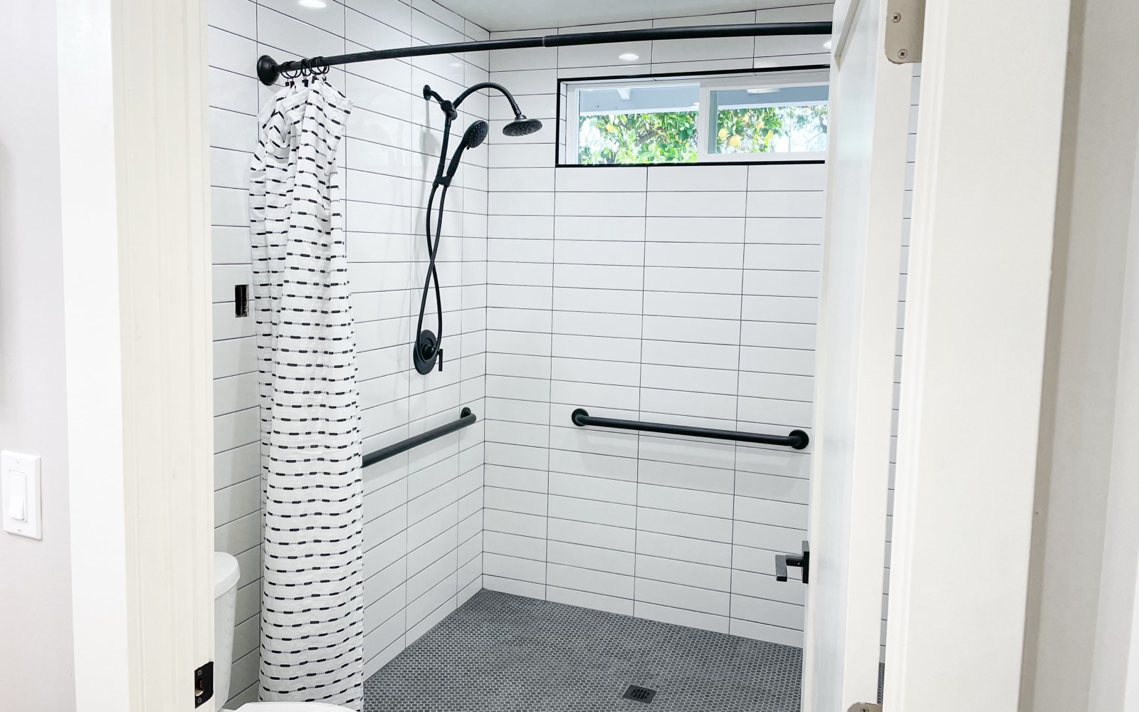 Accessible roll-in shower with grab bars at a New Start Congregate Living Health Facility