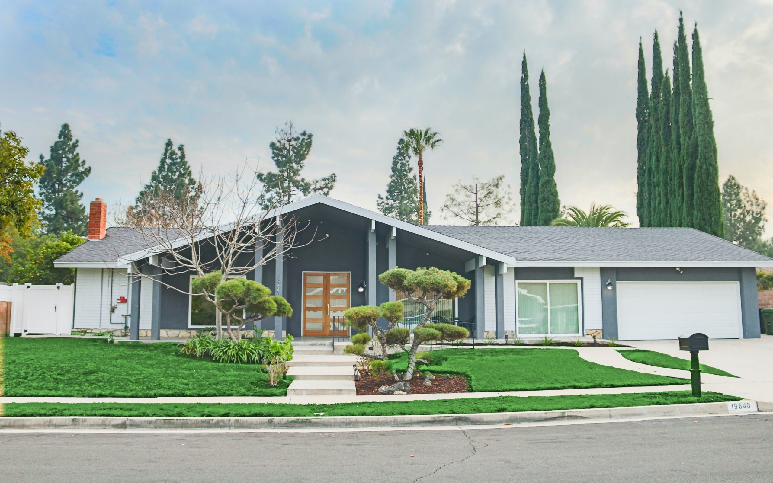 Front exterior of a New Start CLHF residential care home with mid-century architecture and a landscaped yard
